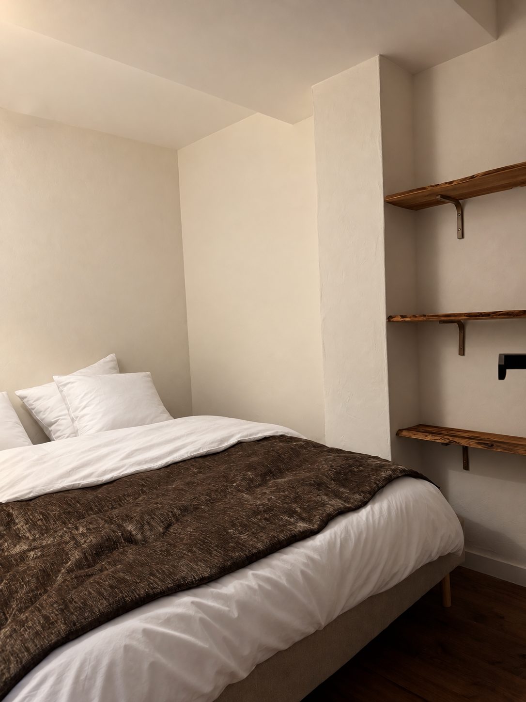 Chambre Queen de l'appartement, lit queen et étagères en bois