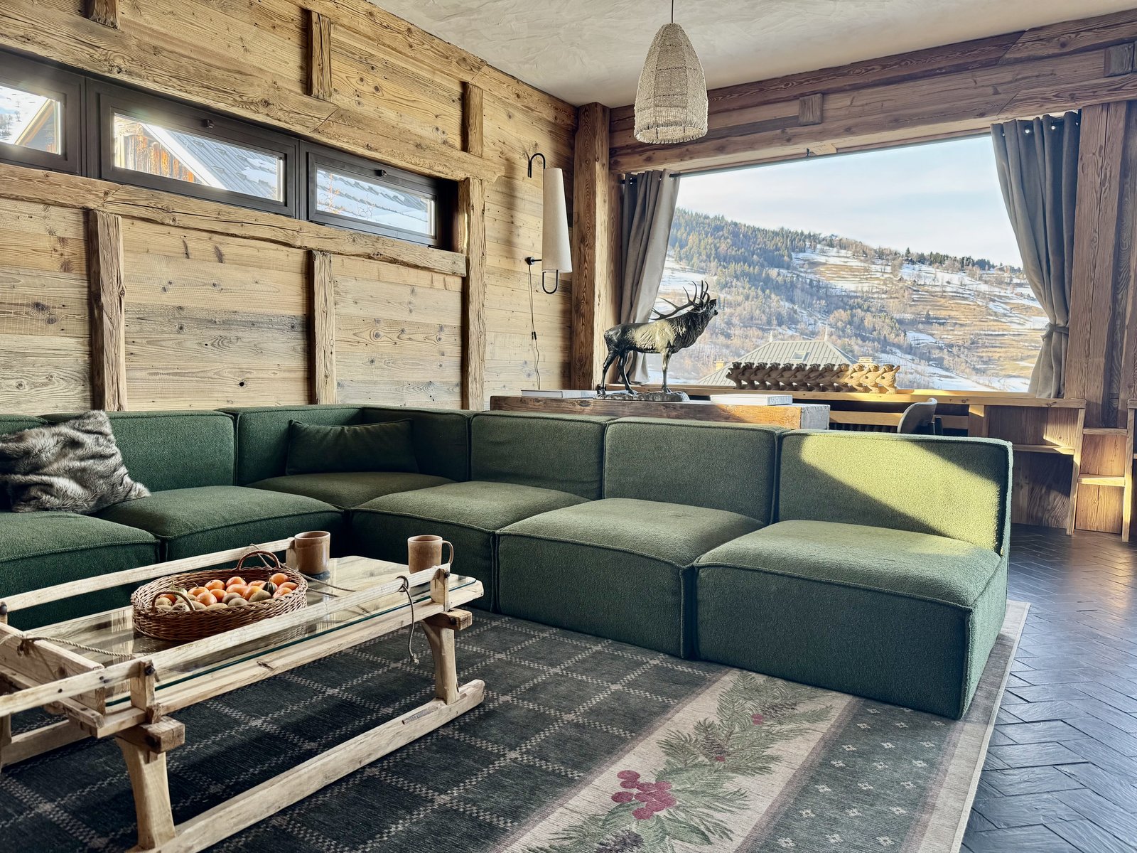 Living room with green bouclé sofa and valley view