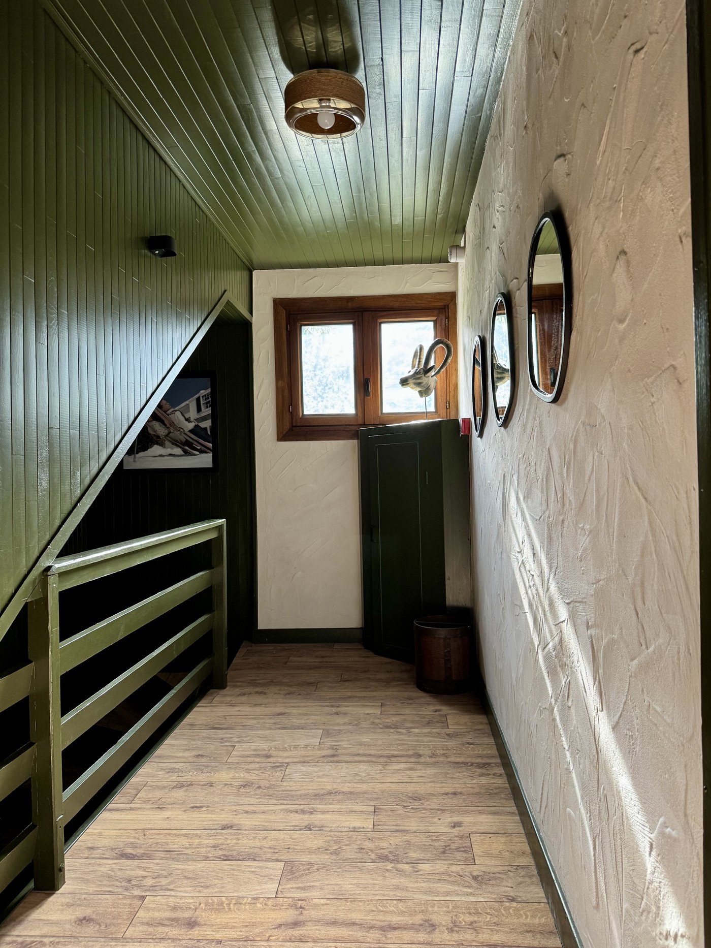 Couloir vert avec tête d'ibex et miroirs ronds