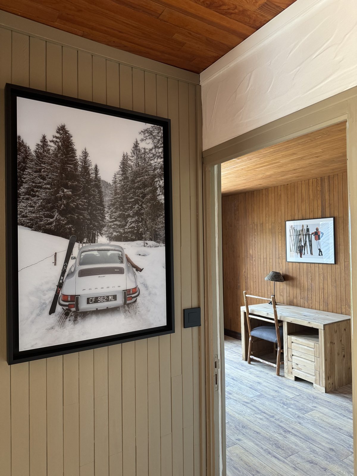 Couloir avec photo de Porsche encadrée menant à une chambre