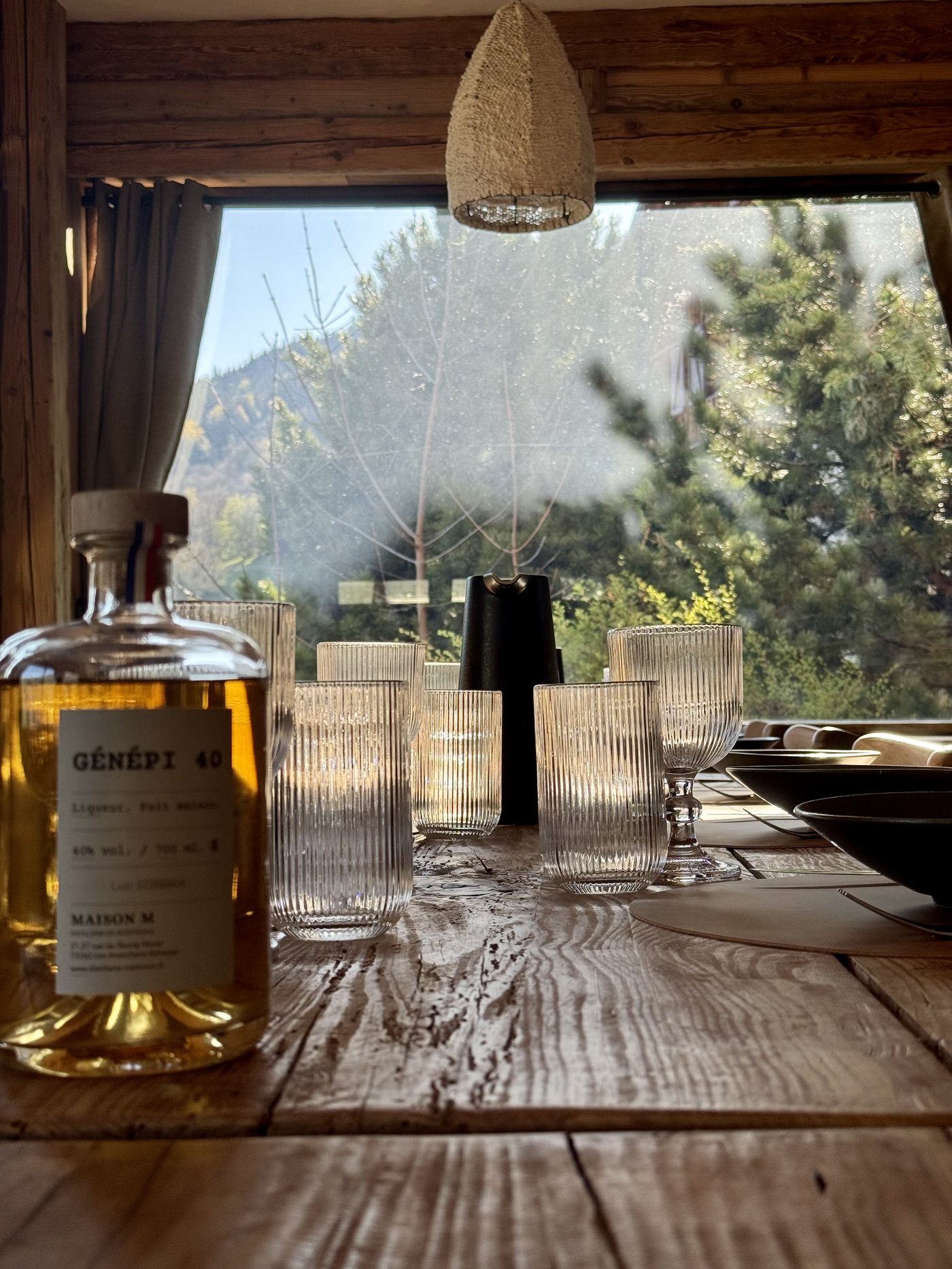 Bouteille de Génépi Maison M sur la table avec verres