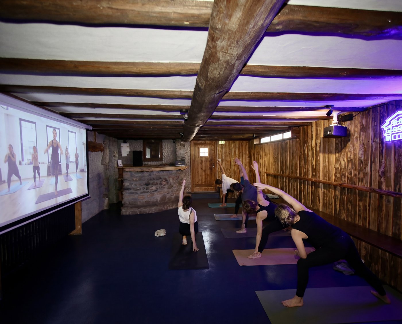 Cours de yoga dans la Family Room avec néon violet