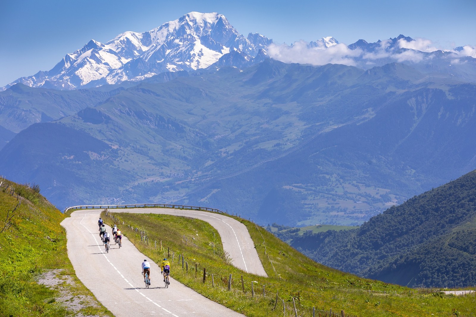 Cyclistes en ascension du Col de la Madeleine, Mont-Blanc en arrière-plan, lacets caractéristiques