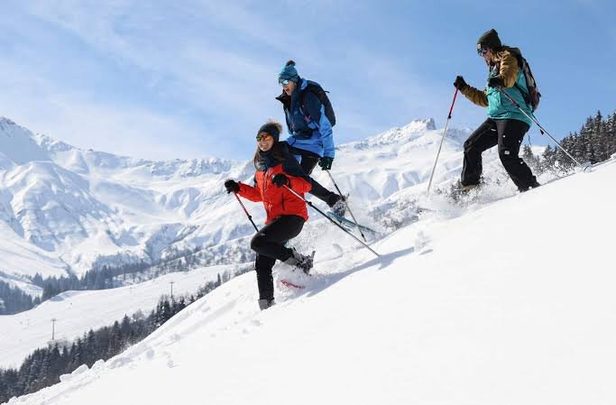 Trio de randonneurs en raquettes sur les pentes enneigées de Valmorel